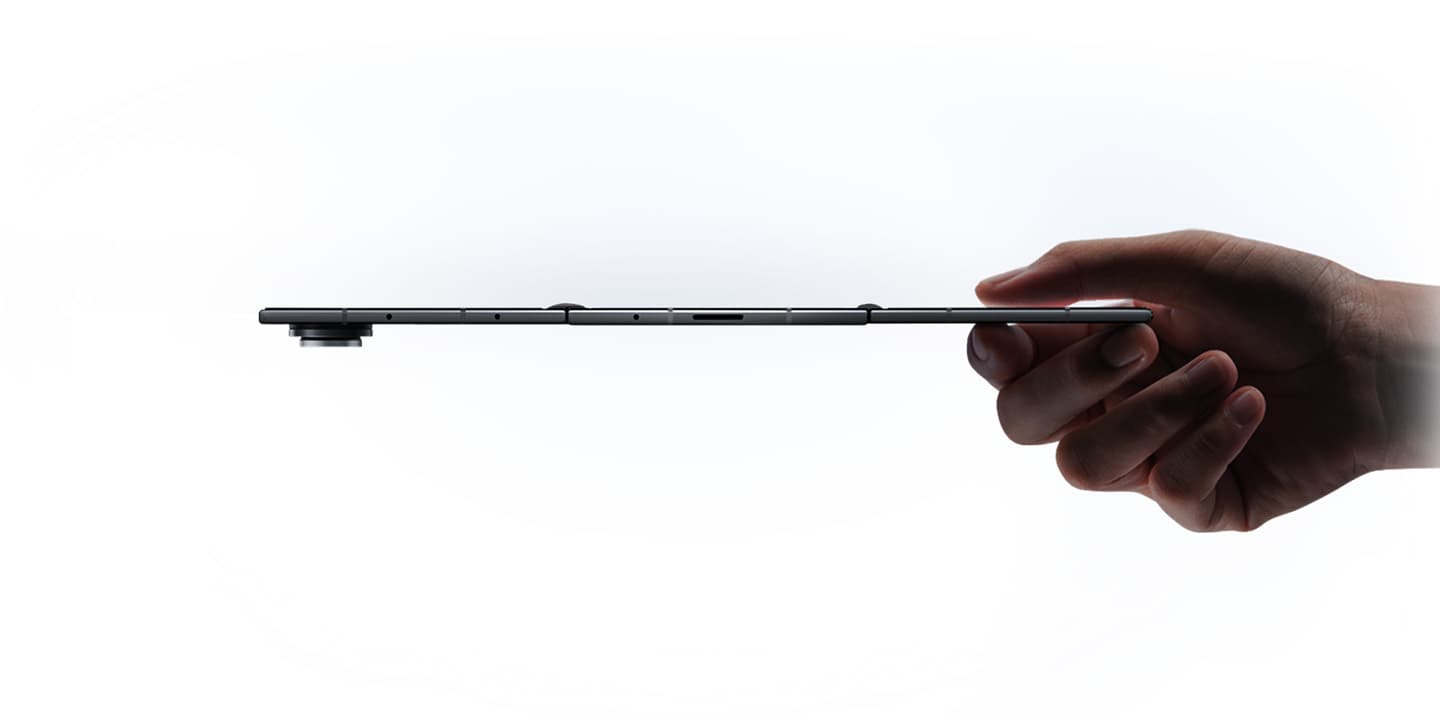 Galaxy Z TriFold held flat between two fingers, showing the ultra-thin unfolded profile