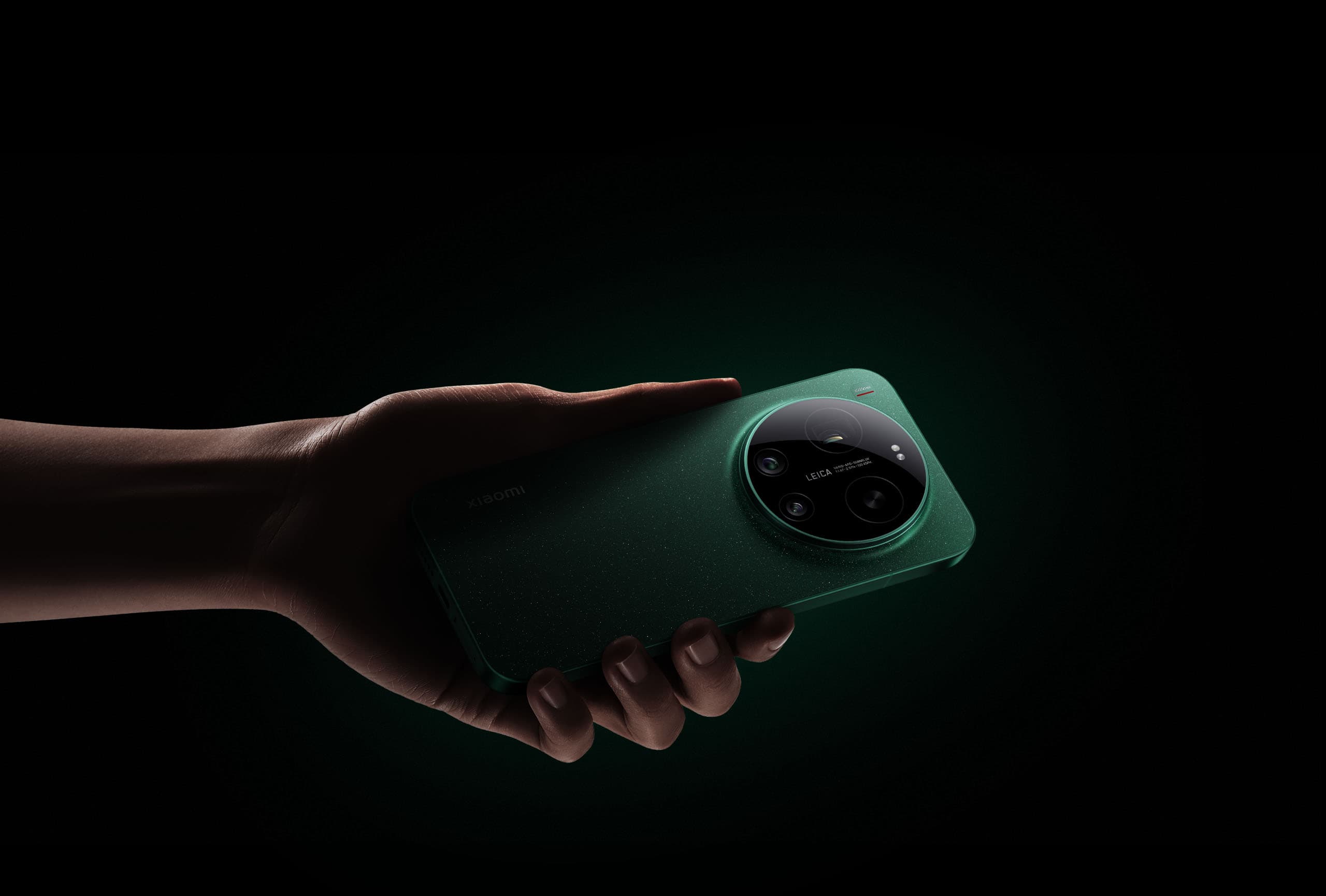 Hånd, der holder Xiaomi 17 Ultra i Starlit Green i dramatisk mørk belysning